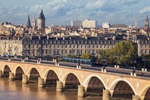 a bridge over a river with a city in the background at Domaine de Cachaou Villa Leyr'ial sauna & spa in Salles