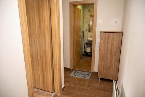 a hallway with a wooden door and a bathroom at All Seasons Apartments Borovets Gardens in Borovets