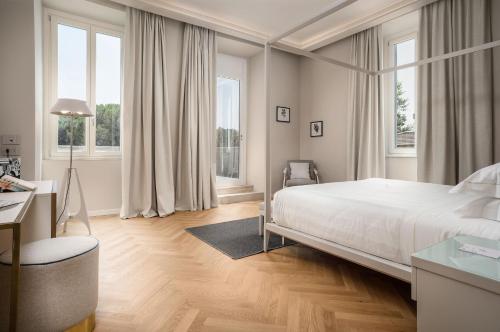 ein weißes Schlafzimmer mit einem großen Bett und Fenstern in der Unterkunft Palazzo BelVedere in Montecatini Terme