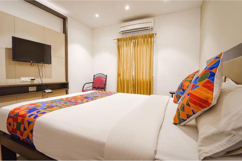 a bedroom with a large bed and a television at FabHotel Karpagam - 900m from Nehru Stadium in Coimbatore