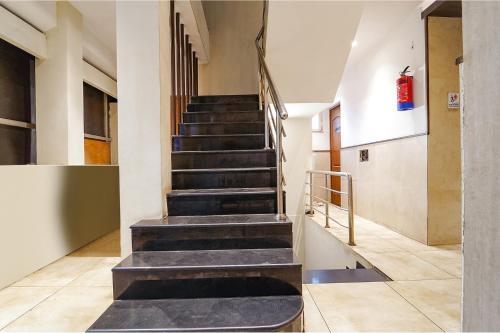 a staircase in a building with a fire extinguisher at FabHotel Karpagam - 900m from Nehru Stadium in Coimbatore