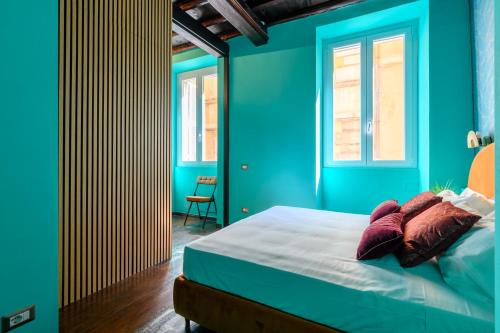 a bedroom with blue walls and a bed with pillows at Riad De’ Fiori in Rome