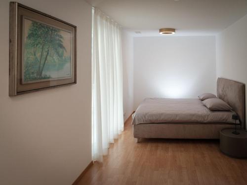 1 dormitorio con 1 cama y una foto en la pared en Apartment Davinci by Interhome en Täsch