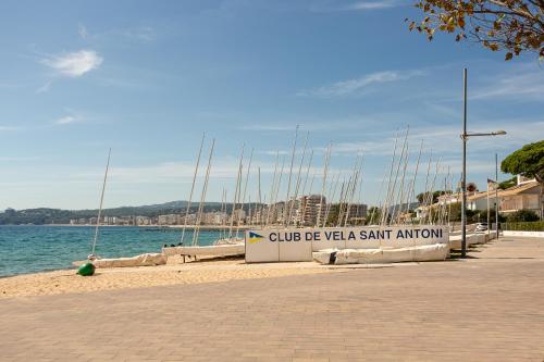 a sign on a beach with boats in the water at Aubi in Palamós
