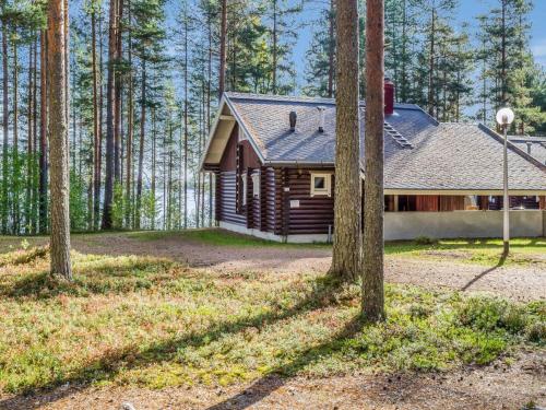 eine Blockhütte im Wald mit Bäumen in der Unterkunft Holiday Home Honkakoli 8 by Interhome in Hattusaari