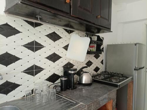 eine Küche mit einer schwarz-weißen Wand in der Unterkunft très joli appartement près de la mer in Kenitra