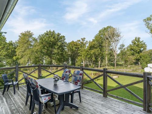 una terraza de madera con mesa, sillas y una valla en Holiday Home Norrgården by Interhome, en Lekeryd