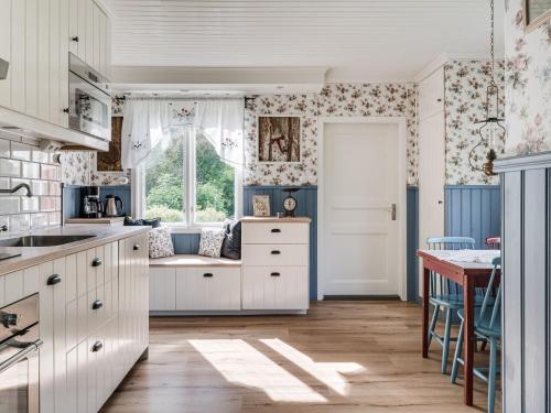 una cocina con armarios blancos y una ventana en Holiday Home Hultet - VGT098 by Interhome en Mullsjö