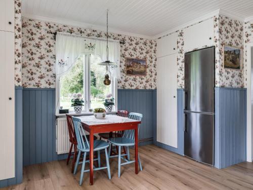 a kitchen with a table and chairs and a refrigerator at Holiday Home Hultet by Interhome in Mullsjö