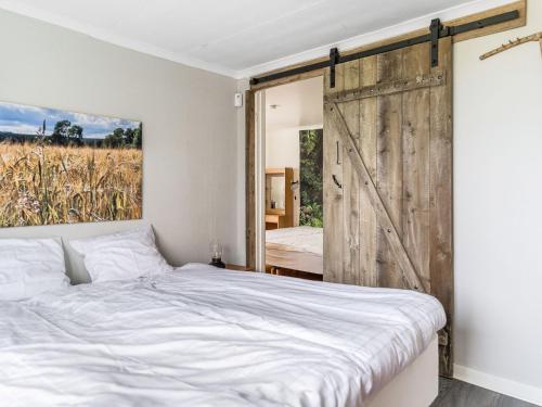 a bedroom with a bed and a sliding barn door at Holiday Home Hultet by Interhome in Mullsjö