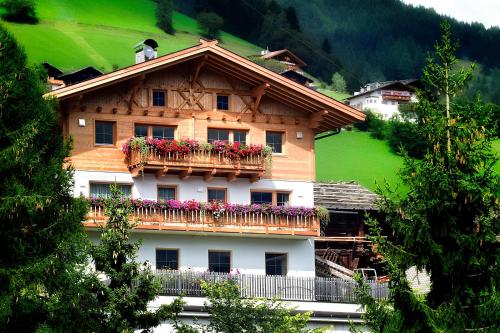 a house with a balcony with flowers on it at Unterdurachhof Apartment Valentina in Ultimo