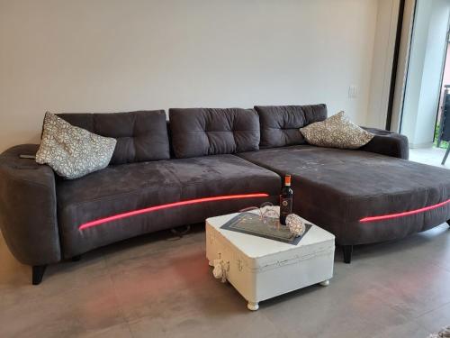 un divano in pelle marrone in un soggiorno con tavolo di Apartment App- Julia Caslano by Interhome a Caslano