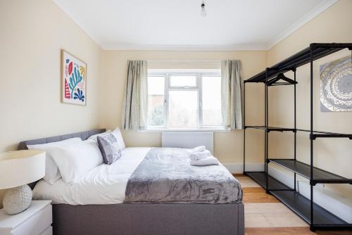 una camera con letto e finestra di 2 Bedroom House by AV Stays Short Lets Croydon With Free Wi-Fi a South Norwood