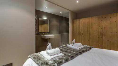 een slaapkamer met een bed met handdoeken erop bij Chalet Aubépines in Chamonix-Mont-Blanc