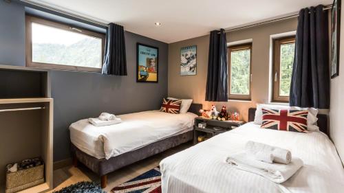 een slaapkamer met 2 bedden en 2 ramen bij Chalet Aubépines in Chamonix-Mont-Blanc