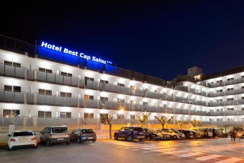 un grand bâtiment avec des voitures garées dans un parking dans l'établissement Hotel Best Cap Salou, à Salou