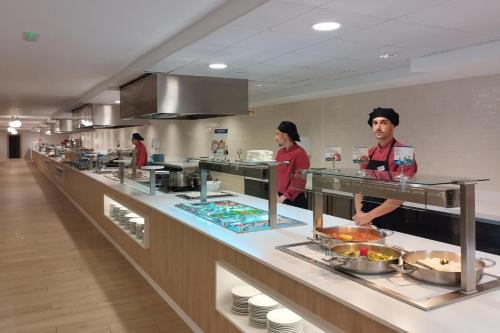 two people standing in a kitchen preparing food at Hotel Best Indalo in Mojácar