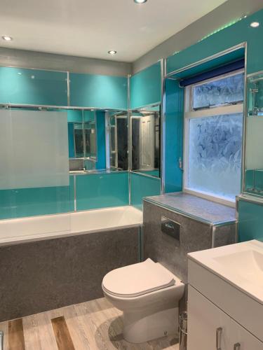 a blue bathroom with a toilet and a bath tub at Entire apartment in central Brighton in Brighton & Hove