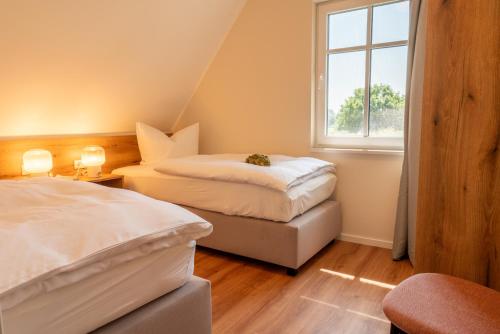 2 Betten in einem Zimmer mit Fenster in der Unterkunft Lieblingshof in Born