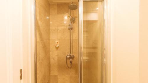 a shower with a glass door in a bathroom at RedDoorz Premium at The Residences Olympia Makati in Manila