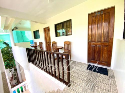 uma escada numa casa com uma porta de madeira em WHITEBEACH DE BORACAY STATION 1 (EXTENSION) em Boracay