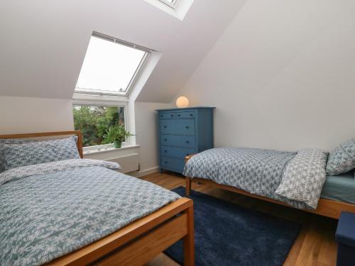 a bedroom with two beds and a window at Hen Gapel in Caernarfon