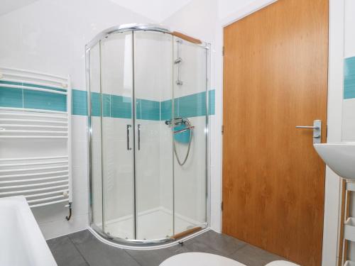 La salle de bains est pourvue d'une douche avec une porte en verre. dans l'établissement Hen Gapel, à Caernarfon