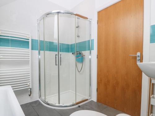 a shower with a glass door in a bathroom at Hen Gapel in Caernarfon