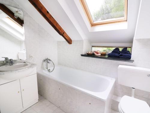 a bathroom with a sink and a bath tub and a window at Loft apartment in Llandysul