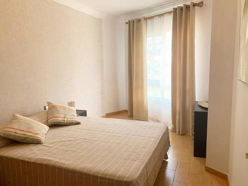 a bedroom with a bed with two pillows and a window at Moon House in La Victoria de Acentejo