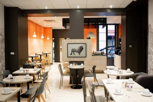 uma sala de jantar com mesas e cadeiras e um restaurante em Mercure Lyon Centre Beaux-Arts em Lyon