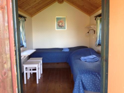 a small bedroom with a blue bed and a table at Kullsbjörken Bed & Breakfast in Tällberg