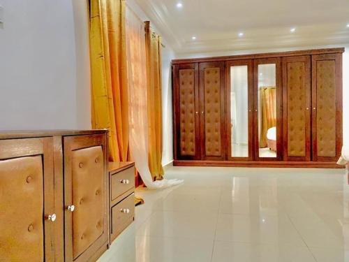 Habitación con armarios de madera y ventana grande. en Résidence Toubab en Toubab Dialaw