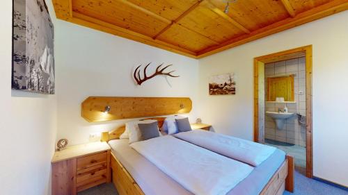 a bedroom with a large bed and a sink at Chalet Tirol Waidring in Waidring