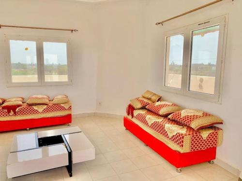 two beds in a room with two windows at Résidence Toubab in Toubab Dialaw