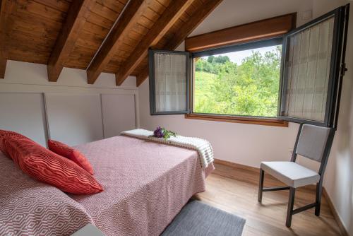 a bedroom with a bed and a window and a chair at Apartamentos Spa Las Caldas y Spa El Balneario in Oviedo