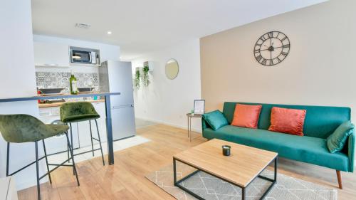 un salon avec un canapé bleu et une table dans l'établissement Studio MAGDA - Fibre et Tv - Calme et confortable, à Saint-Quentin