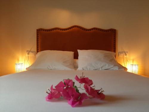 Una cama con flores rosas y dos almohadas en Vivienda Rural Aroche Parralejo Chico, en Aroche