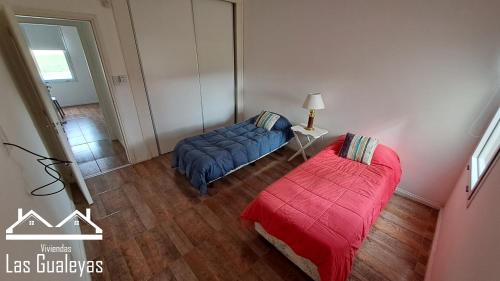 1 dormitorio con cama azul y manta roja en Las Gualeyas en Gualeguay