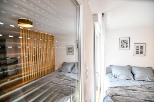 Cette chambre dispose d'un lit et d'une paroi en verre. dans l'établissement Studio MAGDA - Fibre et Tv - Calme et confortable, à Saint-Quentin