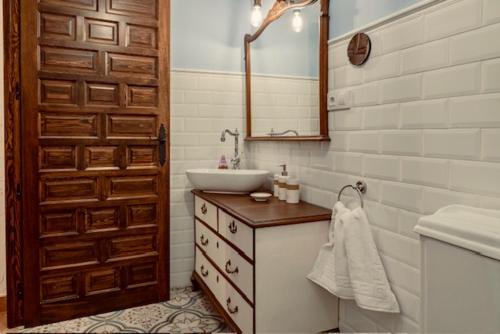 een badkamer met een wastafel en een spiegel bij Casa Rural Villa Margarita in Dosbarrios