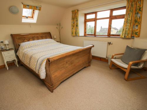 ein Schlafzimmer mit einem Bett und einem Stuhl und einem Fenster in der Unterkunft Rowan Cottage in Shrewsbury