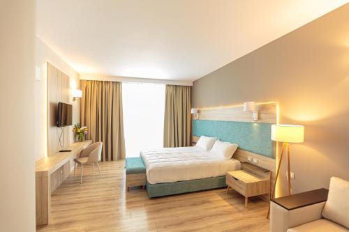 a hotel room with a bed and a desk at Regina Blu in Vlorë