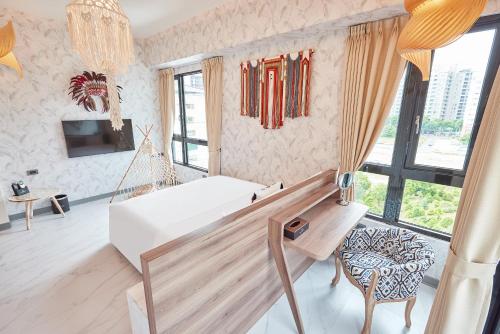a room with a hammock and a couch and windows at 星澄風旅 Zela Design Hotel in Kaohsiung