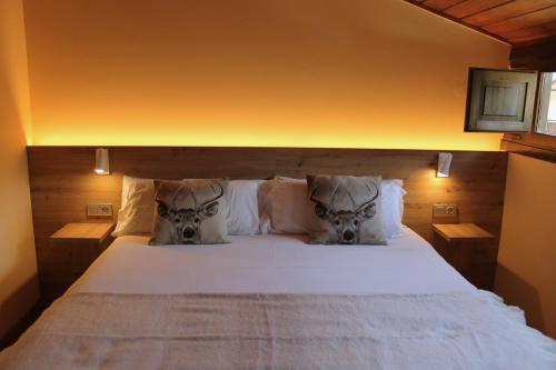 a bedroom with a large bed with white sheets and pillows at Hotel Saurat in Espot