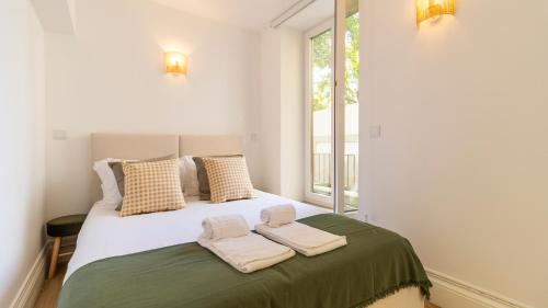 a bedroom with a bed with two towels on it at Urban House Marquês by LovelyStay in Porto