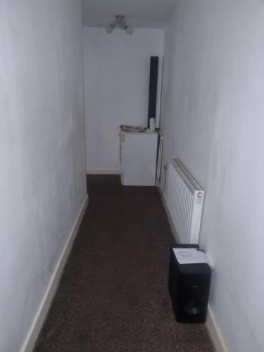 a hallway with a room with a toilet in it at 1 Bet entire flat in Wellingborough