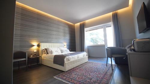 um quarto com uma cama, uma janela e uma televisão em Borea Luxury B&B em Pescara