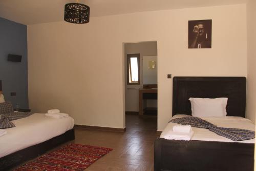 a bedroom with two beds and a rug at Dakhla Camp in Dakhla