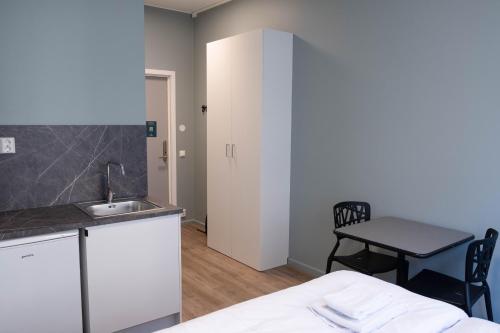 uma cozinha com um lavatório e uma mesa num quarto em Anker Apartment – Grünerløkka em Oslo